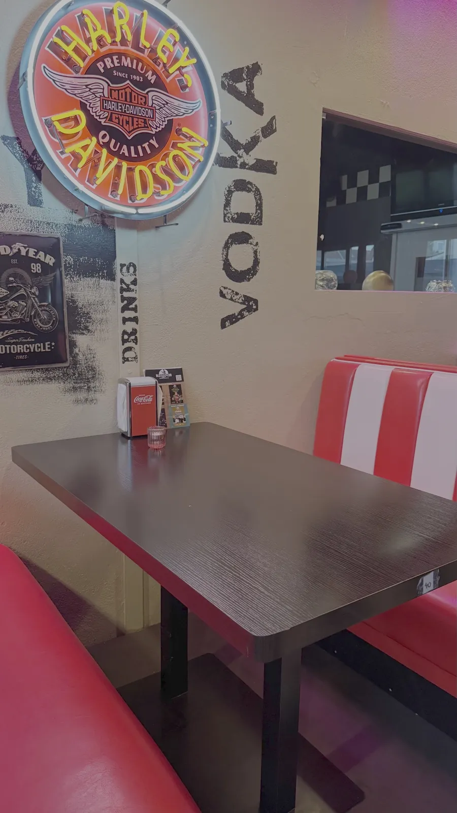Tisch mit Sitzbank unter dem Harley-Davidson-Neon